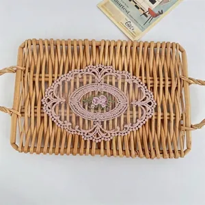 Close-up showing the intricate floral embroidery on a pink hollow lace table mat coaster