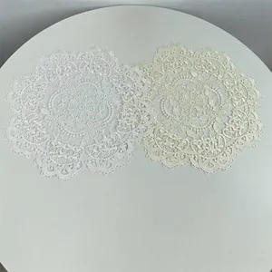Elegant white and cream circular lace embroidered placemats with delicate floral patterns.