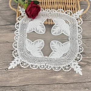 Close-up detail of white vintage embroidered lace placemat with intricate floral pattern