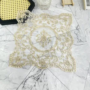 Primer plano detallado de un elegante mantel individual de encaje bordado en beige