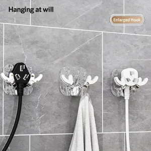 Three chrome antler wall hooks for towel and plug storage on grey bathroom tiles