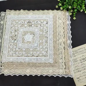 Detailed view of elegant square embroidered lace placemats featuring intricate floral patterns