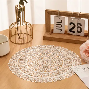 Close-up of a white circular lace woven placemat with intricate floral patterns