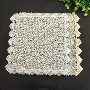 Close-up of elegant square lace crochet coasters in white and beige neutral tones