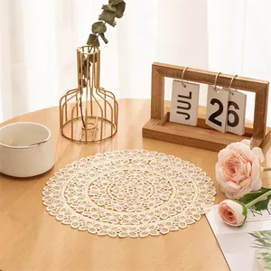 Detail view of an elegant cream round lace doily on a wooden table with floral props.