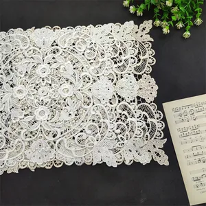 Detailed close-up of a white square lace embroidery placemat with elegant floral patterns