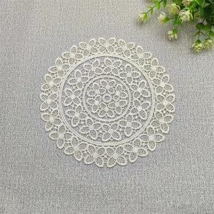 Detailed macro view of an intricate white crochet lace coaster with floral patterns