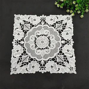 Elegant white square lace embroidered placemat with intricate floral hollow design.