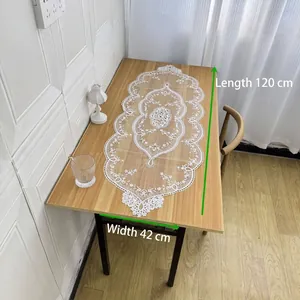 Detalle de camino de mesa de encaje blanco de 120x42 cm sobre una mesa de madera
