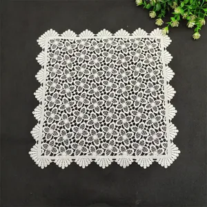 Detailed close-up view of a white floral lace coaster featuring scalloped edges and intricate patterns