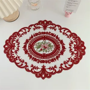 Detailansicht eines eleganten roten Spitzen-Tischsets mit Blumenstickerei für die Deko