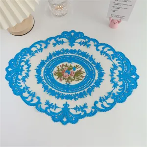 Detailansicht eines eleganten blau bestickten Spitzen-Platzsets mit Blumenmuster