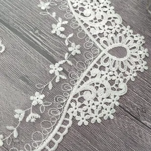 Vista macro de elegante encaje floral blanco calado para decoración textil hogar