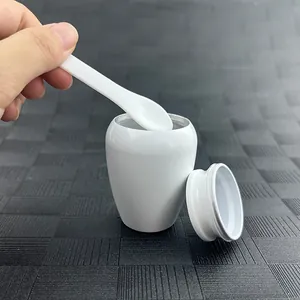 Detailed view of white ceramic cremation urn with spoon for human or pet ashes
