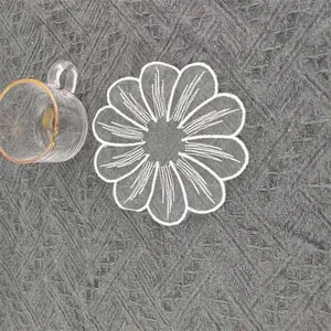 Detailansicht eines weißen kreisförmigen floralen bestickten Spitzenuntersetzers