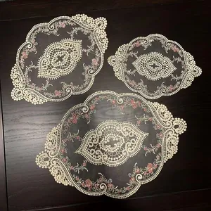 Set of 3 vintage oval lace placemats with pink floral embroidery on dark wooden table