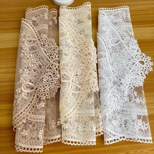 Detailed view of three colors of delicate lace embroidered table runners on a wooden table