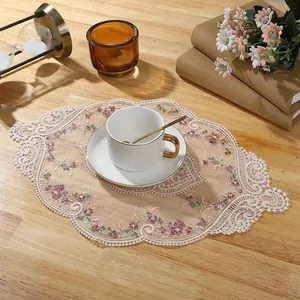 Elegant detail view of the embroidered floral lace placemat on a wooden dining table setup
