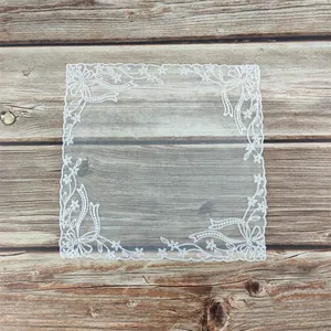 Sierlijke witte kanten placemat met bloemborduurwerk op een houten achtergrond