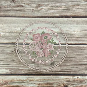 Vista detallada del bordado floral en un mantel individual de encaje francés vintage