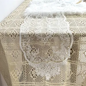 Detailansicht der weißen floralen Spitzenstickerei auf einem Tischläufer im Vintage-Stil
