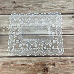 Macro detail van een elegante witte opengewerkte kanten placemat met rozenmotieven