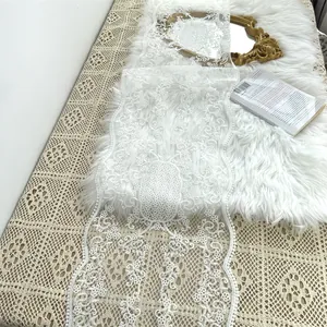 Detaillierte Ansicht eines eleganten weißen Tischläufers aus Spitze mit Stickmustern