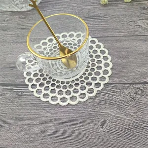Vista detallada del posavasos de encaje bordado vintage con patrón de flores caladas
