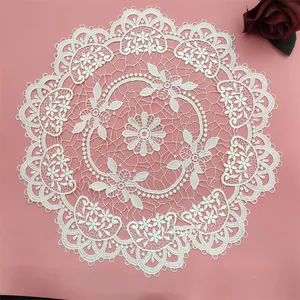 Macro detail of a white Nordic hollow embroidered circular lace placemat for table decor