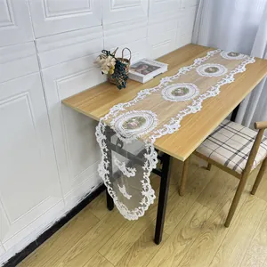 Elegant white lace table runner with floral embroidery shown on a modern wooden dining table