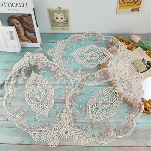 Dettaglio di tovagliette in pizzo francese con ricamo floreale e design traforato