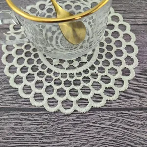 Detalle de posavasos bordado blanco con diseño de encaje floral elegante