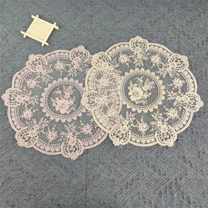 Close-up detail of vintage circular lace placemats featuring intricate floral embroidery.