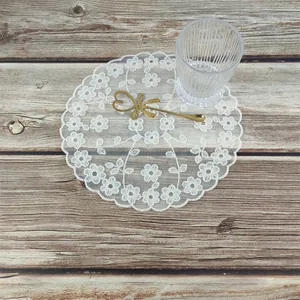 Elegante witte bloemen kant tafelmat op houtoppervlak met lifestyle-accessoires