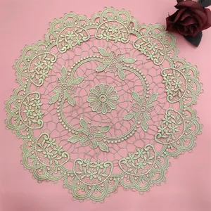 Detailed macro view of intricate gold floral lace embroidery on a round placemat.