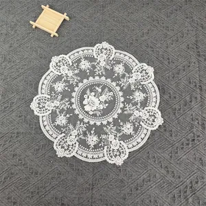 Close-up of vintage round white floral embroidery lace table mat and doily