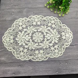 Intricate floral crochet lace placemat showcased on a stylish grey wood grain surface
