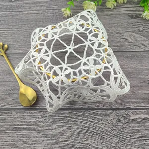 Primer plano de un posavasos de encaje blanco con bordado floral de estilo retro