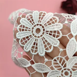 Close-up macro shot showing delicate white hollow embroidered floral lace placemat