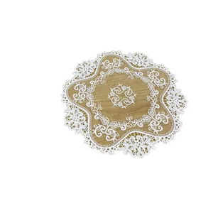 Elegant white lace round doily with intricate floral embroidery on wood background