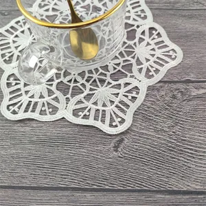 Vista detallada de un posavasos de encaje bordado francés blanco con diseño de flores