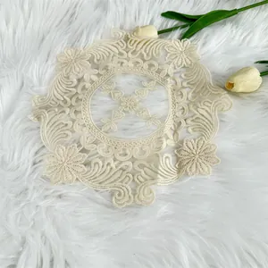 Detailed close-up view of vintage circular milk silk embroidered lace doily on white fur rug