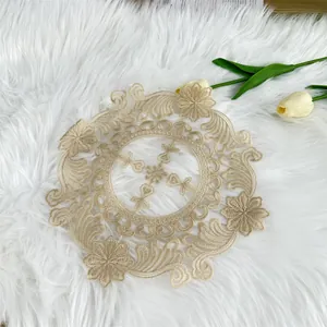 Close-up detail of a vintage circular beige embroidered lace doily on white faux fur
