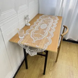 Detailed view of elegant white lace table runner with intricate floral embroidery