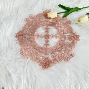 Detailed macro view of elegant pink embroidered lace placemat with floral pattern.