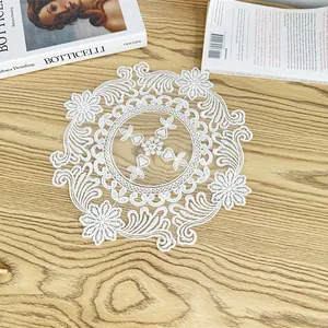 Detail view showing intricate white floral embroidery on circular vintage mesh placemat