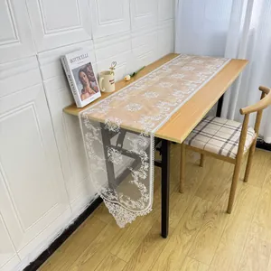 Detail of white embroidered lace table runner with intricate floral hollow design