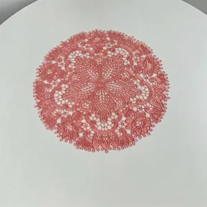 Detail of pink embroidered lace placemat with hollow floral design for table decor
