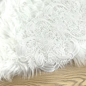 Detail of white floral water-soluble lace placemat with intricate hollow patterns