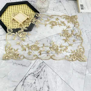 Detalle de cerca de un mantel individual bordado en encaje dorado con textura de malla
